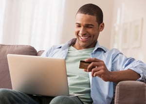 iStock-155773494-man laptop credit card on couch
