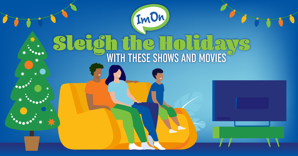Family sitting on couch watching holiday movie on TV